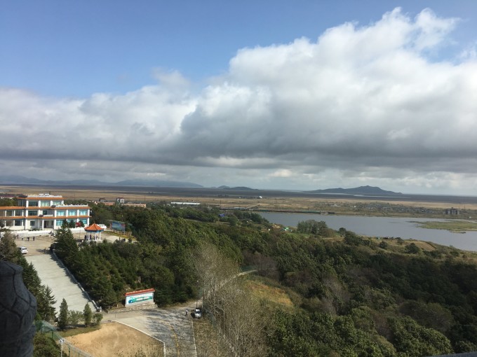市镜泊湖。路上一阵乌云一阵雨,下下停停的。 晚上的路真难开,下了鹤大高速,201国道在修路,坑坑洼洼,无比颠簸。进湖之路真荒凉,成片的庄稼地,找不到个吃饭的地方啊7点多途经梁家村,村口有家农家乐,解决了晚饭。来得太晚,没有更多选择了,店家只能把所有的存货菜都给我们做菜了。太饿了,我们也基本实现了光盘。。 吃饱饭继续赶路进湖,因为住在景区里,车不能开进去,门口停车场收费20块钱/24小时。买票进景区,100块一张票,65岁以上半价,刷指纹进景区门,方便48小时随意进出景区。酒店还不错,派车负责接送,9点多终